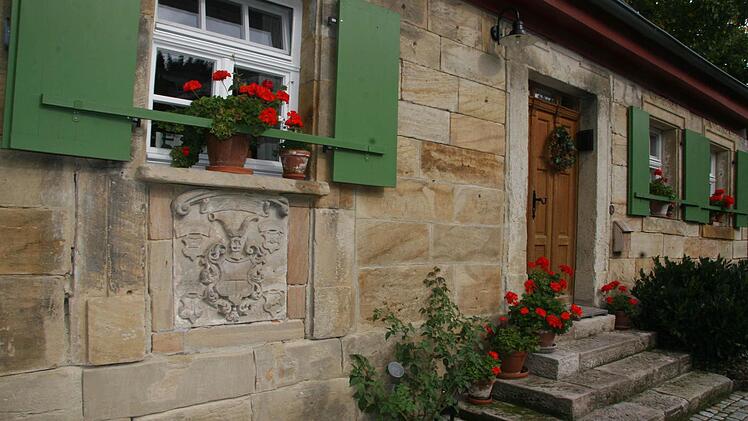 Das Bauernhaus der Familie Jungbauer- im Vordergrund das adelige Wappen.