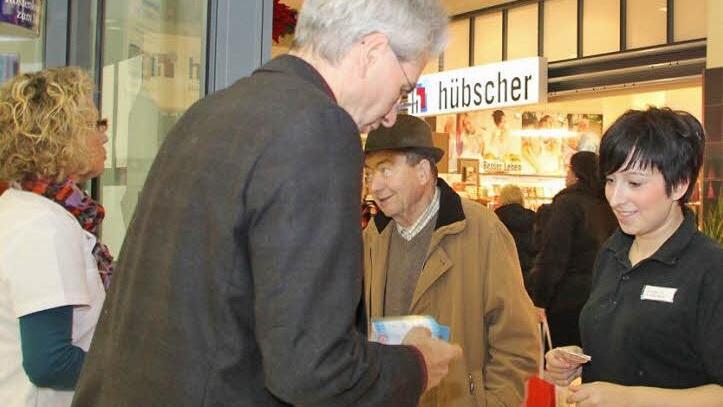 Viktoria Komlowski und Manfred Wende sind irritiert, dass der Weg in die Apotheke versperrt ist. Von Apotheker Hans Peter Hubmann und seiner Mitarbeiterin Bettina Schubert lassen sie sich den Grund für die Protestaktion erklären. Foto: Katrin Geyer