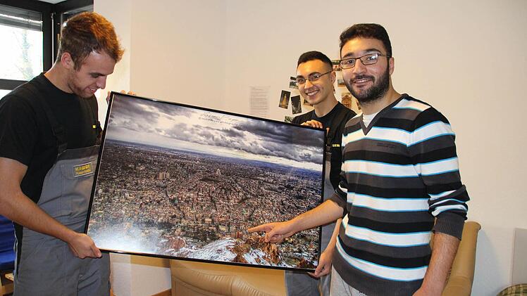 Ayman Shanan und sein Bruder (dahinter) zeigen ihrem Freund Hassan Saddiki aus Spanien, wo ihr Elternhaus in Damaskus steht.