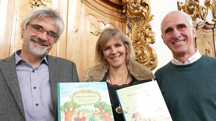 Im Chorgestühl der Stephanskirche präsentieren die Autoren Hubertus Lieberth und Anna Elisabeth Albrecht mit Pfarrer Walter Neunhoeffer (rechts) die Neuerscheinungen.  Foto: Marion Krüger-Hundrup