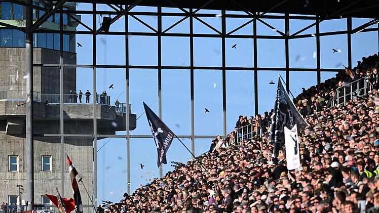 Die Fans des FC St. Pauli beoachten gespannt das Bundesliga-Spiel gegen Bayern M&uuml;nchen am 11. April 2026. Im Hintergrund sieht man den ber&uuml;hmten Hochbunker an der Feldstra&szlig;e, von dem man - mit Gl&uuml;ck - Spiele kostenlos verfolgen kann.