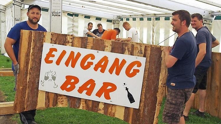 Andreas Bayer (vorne von links) und Sven Pöhlmann sowie weitere Helfer (im Hintergrund) bauen gerade die Bar auf.  Foto: Heike Schülein