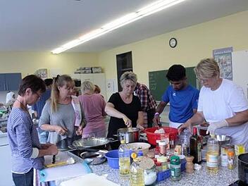 Beim gemeinsamen Kochen in der Kronacher Berufsschule herrschte volle Konzentration. Dennoch war auch Zeit für gemeinsames Singen, Lachen und Austauschen.  Fotos: Heike Schülein
