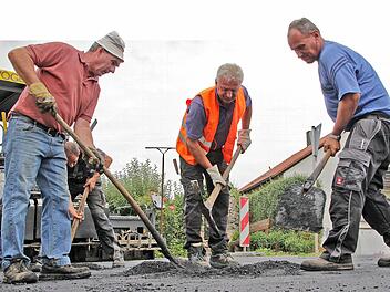 Die Asphaltdecke der Kreisstraße bei Langensendelbach bekommt derzeit per Handarbeit ihren letzten Schliff.  Foto: Andreas Oswald