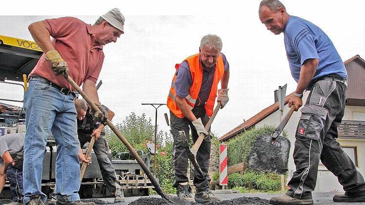 Die Asphaltdecke der Kreisstraße bei Langensendelbach bekommt derzeit per Handarbeit ihren letzten Schliff.  Foto: Andreas Oswald