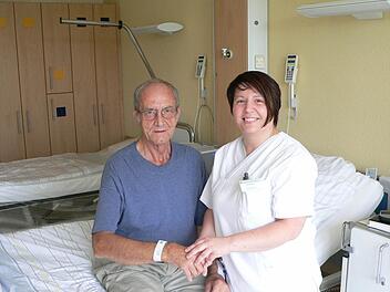 Schwester Juliana Varro mit dem Patienten Willi Voll beim Anlegen des Patientenarmbandes.  Foto: Helios