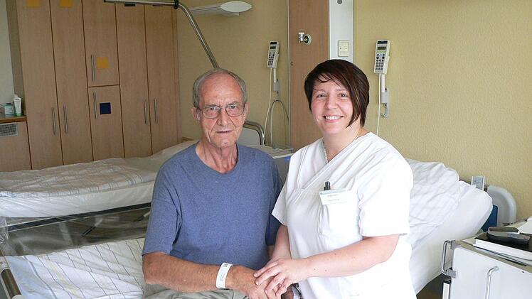 Schwester Juliana Varro mit dem Patienten Willi Voll beim Anlegen des Patientenarmbandes.  Foto: Helios