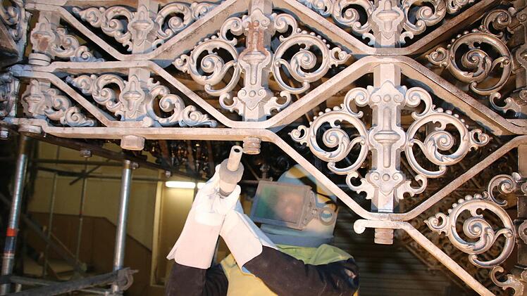 Auch das Sandstrahlen der gußeisernen Ornamente in den Treppenhäusern geht voran: Dazu muss sich Restaurator Max Herwig von der Spezial-Firma Ostmann und Hempel aus Wilsdruf dick einpacken