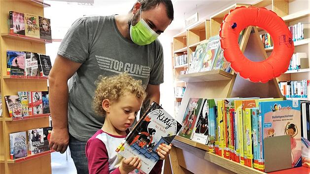 Noch zu jung f&uuml;r den Sommerferien-Leseclub, aber B&uuml;cher mag Edwina Schlereth (4, mit Vater Daniel) jetzt schon. Foto: Sigismund von Dobsch&uuml;tz