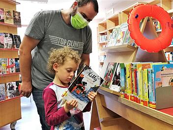 Noch zu jung für den Sommerferien-Leseclub, aber Bücher mag Edwina Schlereth (4, mit Vater Daniel) jetzt schon. Foto: Sigismund von Dobschütz