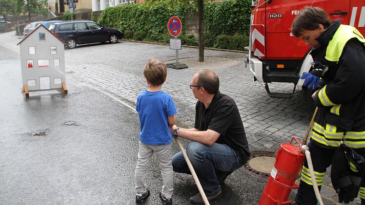 Landrat Christian Meißner und Sohn Benedikt beim Löschen an einem Übungs-Brandhaus.