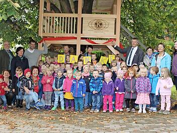 Die Kinder und Kindergärtnerinnen des Rosenberg-Kindergartens bedankten sich bei Markus Stöckert (hinten, dritter von links) und Kiwanis-Club-Präsident Thomas Luger (hinten, vierter von rechts) für ihr neues Baumhaus. Foto: Corinna Igler