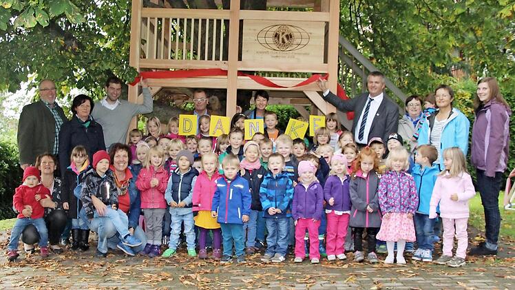 Die Kinder und Kindergärtnerinnen des Rosenberg-Kindergartens bedankten sich bei Markus Stöckert (hinten, dritter von links) und Kiwanis-Club-Präsident Thomas Luger (hinten, vierter von rechts) für ihr neues Baumhaus. Foto: Corinna Igler
