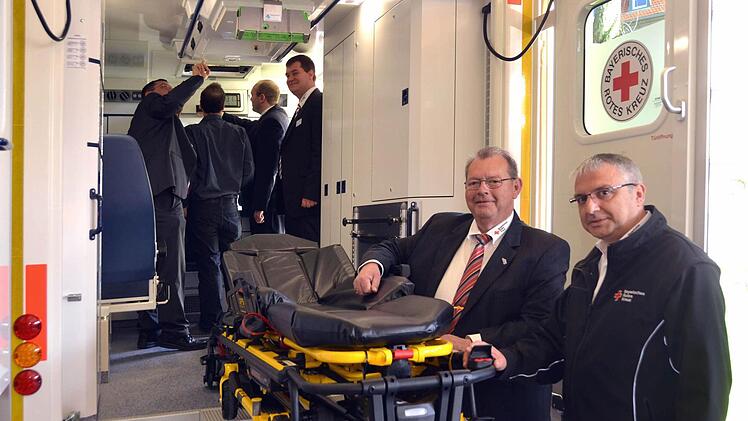 Peter Hausl (Bereichsleiter Rettungsdienst des Bayerischen Roten Kreuzes) besichtigt zusammen mit dem Kissinger Rettungsdienstchef Rudolf Bayer (vorne) einen der gezeigten ganz modernen Schwerlast-Rettungswagen. Mit solchen Fahrzeugen, die inzwischen bayernweit flächendeckend stationiert sind, können auch sehr stark übergewichtige Patienten adäquat transportiert werden. Foto: Peter Rauch