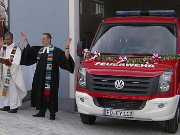 Kaplan Jimmy (l.) und Pfarrer Ulrich Hardt spenden in Dorfhaus dem neuen Feuerwehrauto ihren Segen. Fotos: Malbrich