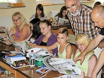 Lehrer Walter Kuhn (oben) und Redakteur Ralf Ruppert (rechts) besprechen mit den Schülerinnen (erste Reihe, von links) Judith Gran, Magdalena Zeier, Maria Allitaj, Pia Schlereth und Seline Rein den Aufbau der Saale-Zeitung. Hinten sind Aileen Resch und Ann-Kathrin Henkel zu sehen. Fotos: Ralf Ruppert / Sebastian Vogt
