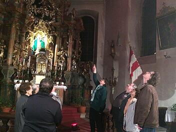 Kirchenführerin Annette Urban zeigt auf ein Deckengemälde, das die Ansammlung der Apostel um die in den Himmel steigende Muttergottes Maria herum darstellt. Mit im Bild Gemeindereferent  Matthias Beck (rechts) und Pater Waldemar Brysch (3.v.r.)Foto: K.- H. Hofmann