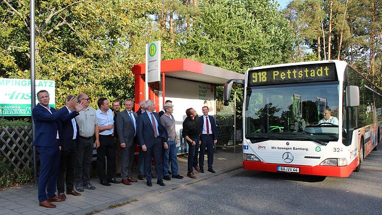 Endlich naht der Pettstadter Bus: Bürgermeister Jochen Hack (links) mit  Gästen aus Bamberg und Pettstadter Gemeinderäten üben Schlange stehen an  der Haltestelle.     Foto: Werner Baier