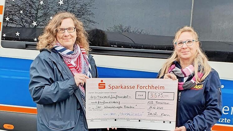 Karin Fenzl (rechts) und ihre Schwester Elke Seeler, die mitgestrickt hat, mit dem Scheck f&uuml;r den "W&uuml;nschewagen Franken" Foto: privat