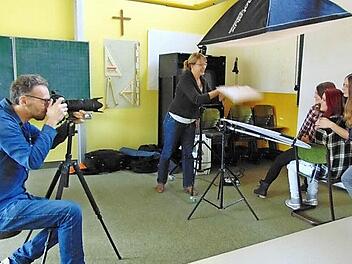Fotograf Michael Schobe macht Porträtaufnahmen von Sarah Forster, Adriana Marsing und Laura Siebenhaar. Christiane Arndt fächert den Mädchen mit einem Stück Pappe ein bisschen Luft zu. Fotos: Petra Malbrich