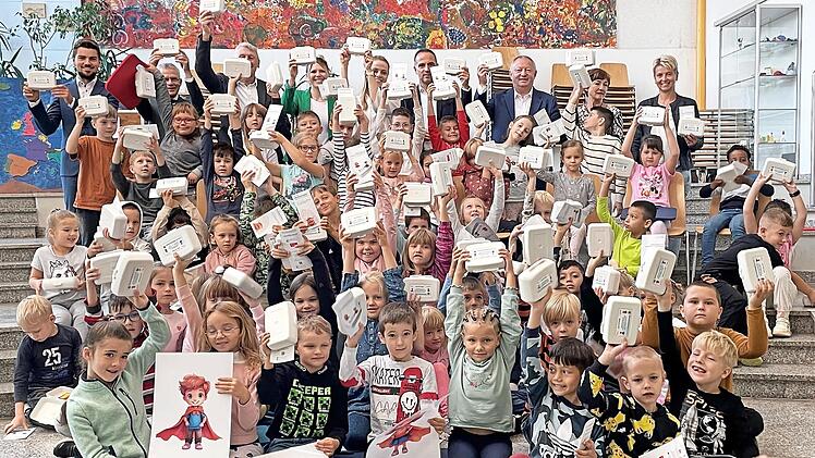 Die Erstklässler der Grundschule in Bad Brückenau mit ihrer nachhaltig hergestellten „Klimahelden-Brotdose“: Überreicht wurden sie von Landrat Thomas Bold, Jürgen Metz, Vorstand des Kommunalunternehmens, Roland Friedrich, Vorstandsvorsitzender der...