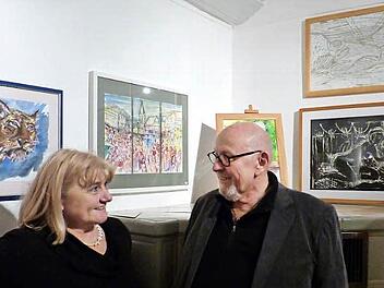 Anita Huppmann und Reinhard Greipel in ihrer Ausstellung. Zwischen den beiden Künstlern ist eine Ansicht vom Zeiler Marktplatz zu sehen - dreigeteilt und mit einiger künstlerischer Freiheit entstanden.  Foto: Klaus Schmitt