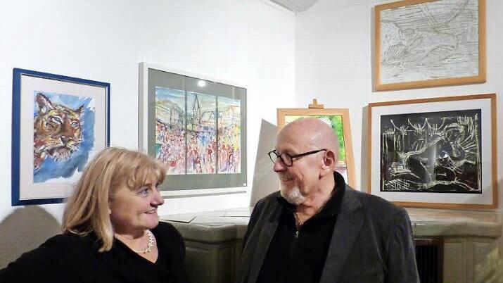 Anita Huppmann und Reinhard Greipel in ihrer Ausstellung. Zwischen den beiden Künstlern ist eine Ansicht vom Zeiler Marktplatz zu sehen - dreigeteilt und mit einiger künstlerischer Freiheit entstanden.  Foto: Klaus Schmitt