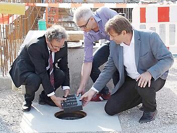 Ewald Maier, Vorstand der Sparkasse Forchheim, Oberbürgermeister Uwe Kirschstein und Landrat Hermann Ulm legen den Grundstein für die „Statt-Häuser“.