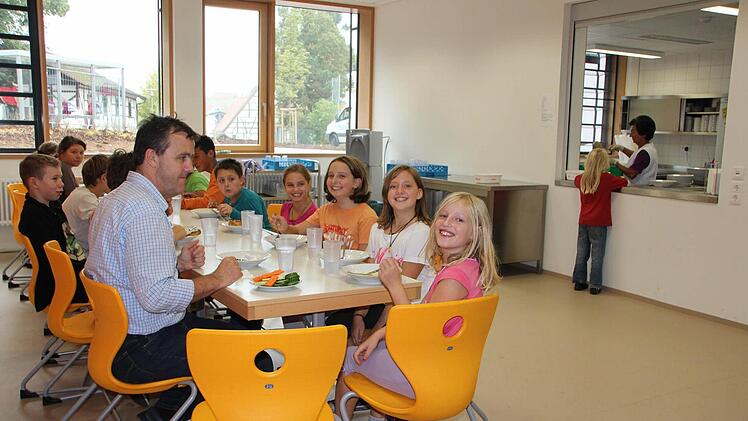 Gemeinsam mit Schulleiter Andreas Kehl haben es sich einige Schüler schon ein Tag vor der großen Einweihungsfeier das Mittagsessen in der neuen Mensa schmecken lassen.