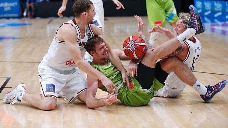 Auch für den Bodenkampf war sich der "Bamberger" Janis Strelnieks nicht zu schade. Hier versucht der Lette mit seinem Teamkollen Jannis Timma dem slowenischen NBA-Spieler Zoran Dragic den Ball wegzunehmen. Foto: Yoan Valat/dpa
