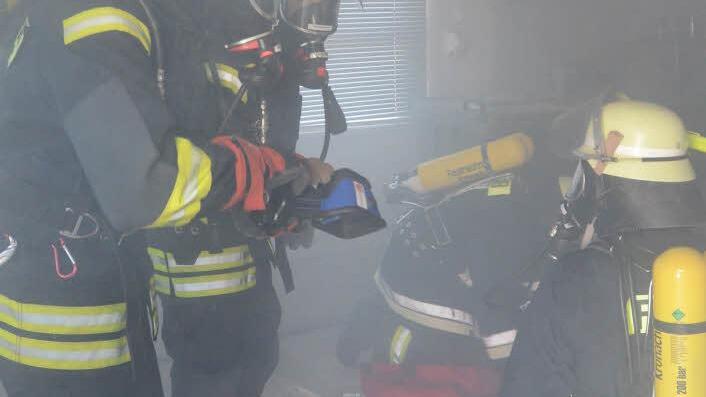 Die Atemschutztrupps spürten mit Wärmebildkamera in starker Rauchentwicklung des Kellergeschosses zwei Personen und zwei Gasflaschen auf und brachten diese in Sicherheit. Foto: Karl-Heinz Hofmann