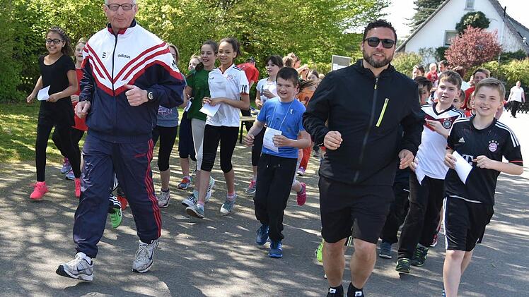 Der Bürgermeister der Gemeinde Ahorn, Martin Finzel, und Weltmeister Hermann Beckering laufen mit und motivieren die Schüler beim Spendenlauf. Foto: Gabi Arnold