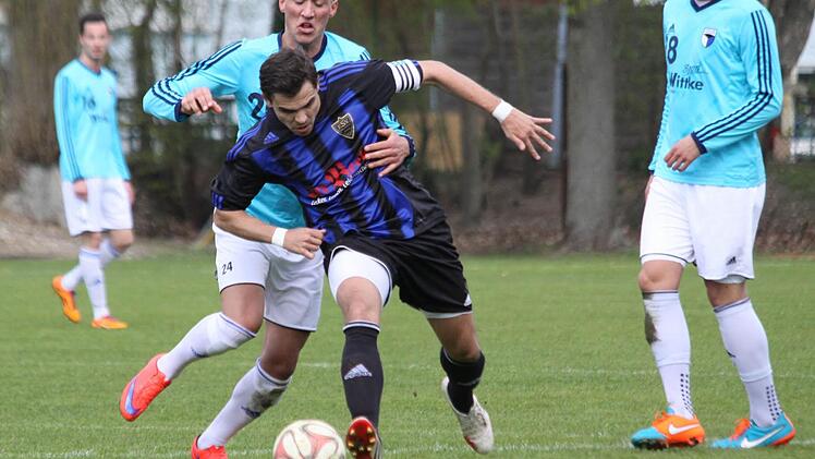 Der Forchheimer Mergim Bajrami und der Erlanger Karlheinz Wiesenmayer beharken sich im Mittelfeld. Der Jahn-Jungspund trug mit seinem 2:0 entscheidend zum Derby-Sieg bei. Fotos: Uwe Kellner