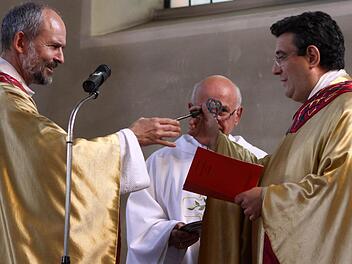 Die Übergabe des Petrusschlüssels dokumentiert als äußeres Zeichen die Übernahme. Prodekan Armin Haas überreicht diesen dem neuen Stadtpfarrer, Dekan Michael Krammer. Foto: Thomas Dill