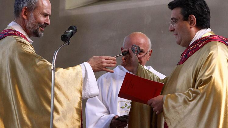 Die Übergabe des Petrusschlüssels dokumentiert als äußeres Zeichen die Übernahme. Prodekan Armin Haas überreicht diesen dem neuen Stadtpfarrer, Dekan Michael Krammer. Foto: Thomas Dill