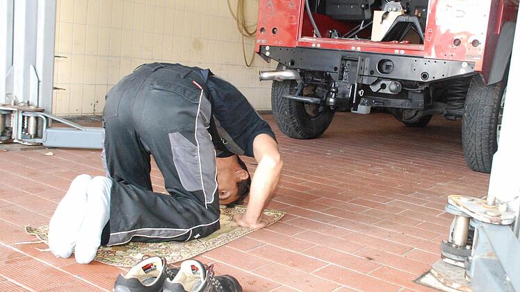 Drei Mal am Tag betet Mohammad Qasemi auf seinem Gebetsteppich in der Werkstatt des Autohauses. Wichtig ist die Richtung gen Mekka, das Umfeld spielt keine Rolle.