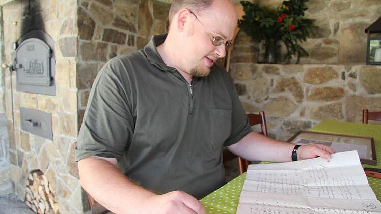 Hans Pezold hält die Familientradition in Ehren und stöbert gerne in den historischen Fundstücken, selbst der Kaufvertrag für das Anwesen ist noch vorhanden. "Man kann die Grundstücke genau an den Flurnummern erkennen. Die haben sich nicht geändert", ist Hans Pezold begeistert. Fotos: Sonja Adam