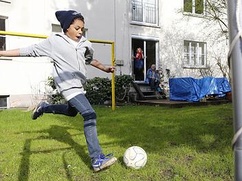 Mutter Ricarda und Opa Norbert schauen Lian beim Kicken im Garten zu. Foto: Matthias Hoch