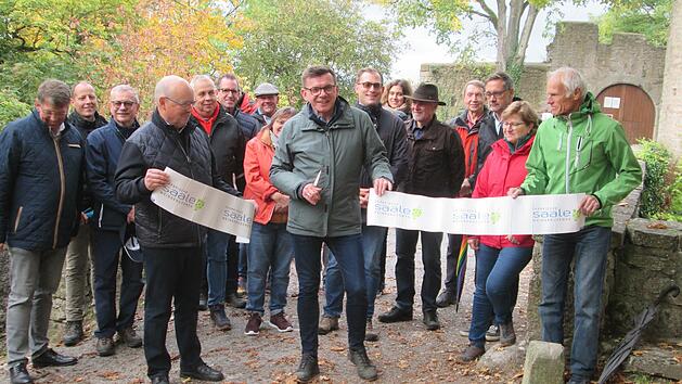 Mit dem Zerschneiden des Bandes eröffnete Bürgermeister Armin Warmuth (Mitte), Sprecher von Frankens Saalestück und die Vize-Bürgermeister von Gemünden, Werner Herrbach (links) und Bad Kissingen, Richard Fix (rrechts) den neuen Wein- und Genusswanderweg vor den Toren der Trimburg.