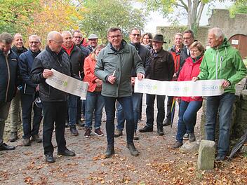 Mit dem Zerschneiden des Bandes eröffnete Bürgermeister Armin Warmuth (Mitte), Sprecher von Frankens Saalestück und die Vize-Bürgermeister von Gemünden, Werner Herrbach (links) und Bad Kissingen, Richard Fix (rrechts) den neuen Wein- und Genusswanderweg vor den Toren der Trimburg.