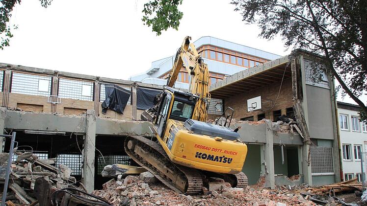 Der Abrissbagger beißt sich durch die alten Turnhallen. Im Hintergrund ist der Kollegstufenbau des Gymnasiums zu sehen. Foto: Andreas Dorsch