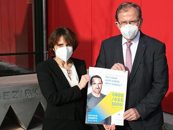 "Sei stark und wähle dein Leben." Mit diesem Satz wirbt der bekannte Extrembergsteiger Alexander Huber für die Krisendienste, die die bayerischen Bezirke jetzt auf den Weg bringen. Das Foto zeigt Bezirkstagspräsident Erwin Dotzel und die Verantwortliche für die Leitstelle des Krisennetzwerks Unterfranken, Dr. med. Simona Kralik. Foto: Markus Mauritz