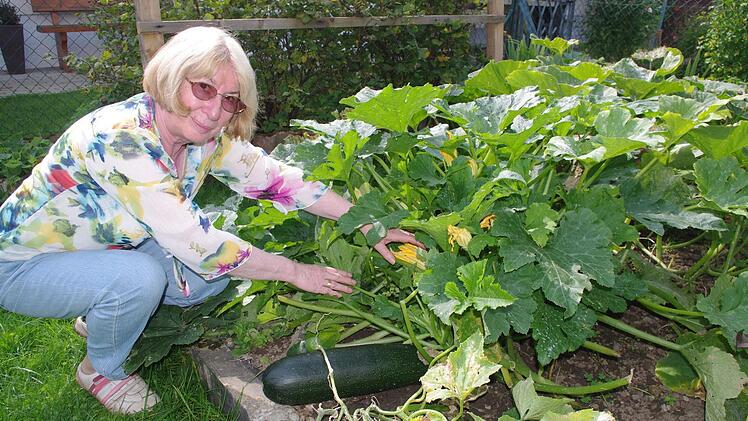 Helga Fleischmann freut sich über große Zucchini und Gurken in ihrem Garten. Foto: Heike Schülein
