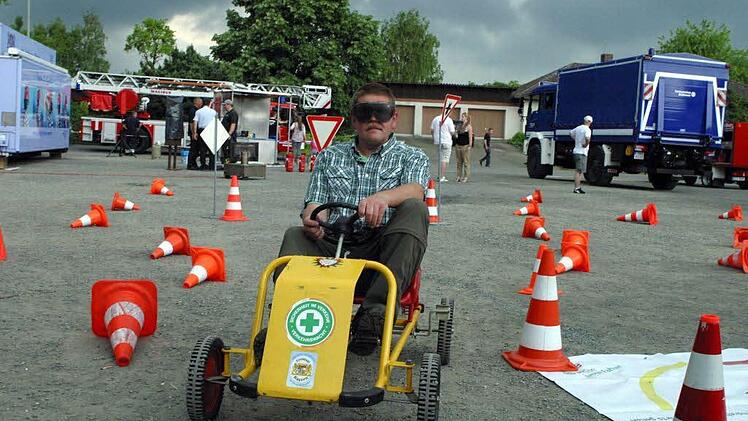 Andreas Borst aus Ebern probiert mit der Brille der Verkehrswacht aus, wie sich eine Kettcar-Fahrt unter Alkoholeinfluss meistern ließe.