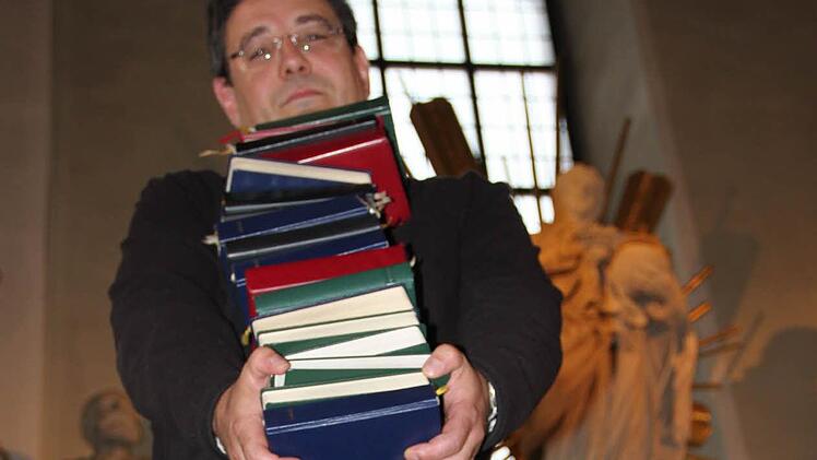 Pfarrer Michael Krammer muss nicht nur Gesangbücher schleppen, sondern sich um eine Vielzahl von Aufgaben kümmern. Foto: Ulrike Müller