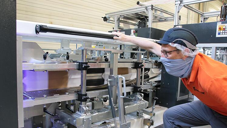 Edwin Rath arbeitet seit fast 30 Jahren bei Mondi, er hat den Umzug von Karlstadt nach Westheim mitgemacht. Hier begutachtet der Schichtführer das Aufklappen der Papierschläuche und das Verkleben des Bodens in der neuen Produktionsstraße. Foto: Ralf Ruppert