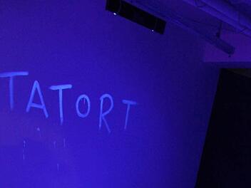 Natürlich ist im ehemaligen Schlecker-Markt nicht wirklich ein Mord passiert, aber zur Tatort-Zeit hat Lichtkünstlerin Elke Harras aus Nordhalben die Kulisse in Szene gesetzt. Der Tatort ist mit Farbe, die nur in Schwarzlicht zu sehen ist, auf die Wand gemalt.