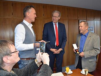 Klaus Neujahr dokumentiert die Übergabe (von links): Torben Lüttschwager, German Hacker, Willi Mehler