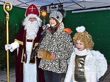 Bürgermeisterin Christine Frieß, das Christkind (Mata Schneider) und der Weihnachtsmann (Joachim Ruß) empfangen zu Beginn des Weihnachtsmarkts die Besucher.
