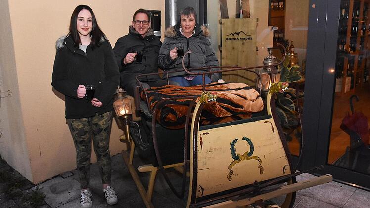 Renée Büchner und seine Frau Sabine (in einem alten Schlitten) beteiligen sich am "Haßfurter Funkeln" und öffnen den Hof des Weinhauses Schaffner. Mit im Bild Tochter Jule (links).
